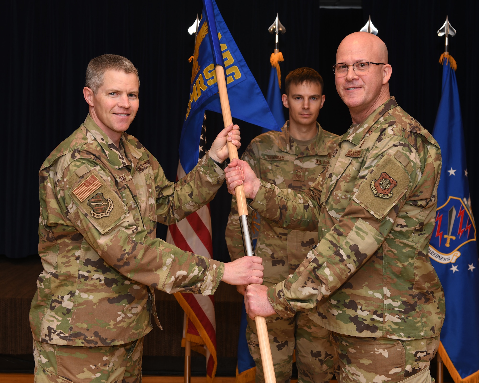Col. Sam Johnson, 21st Space Wing vice commander, left, presents the guidon to Col. Marshall T. Hayes, incoming 21st Operational Medical Readiness Squadron commander July 19, 2019, Peterson Air Force Base, Colorado. The 21st Medical Group recently underwent a change when the 21st Aerospace Medicine Squadron was redesignated as part of the 21st OMRS. (U.S. Air Force photo by Airman 1st Class Andrew Bertain)
