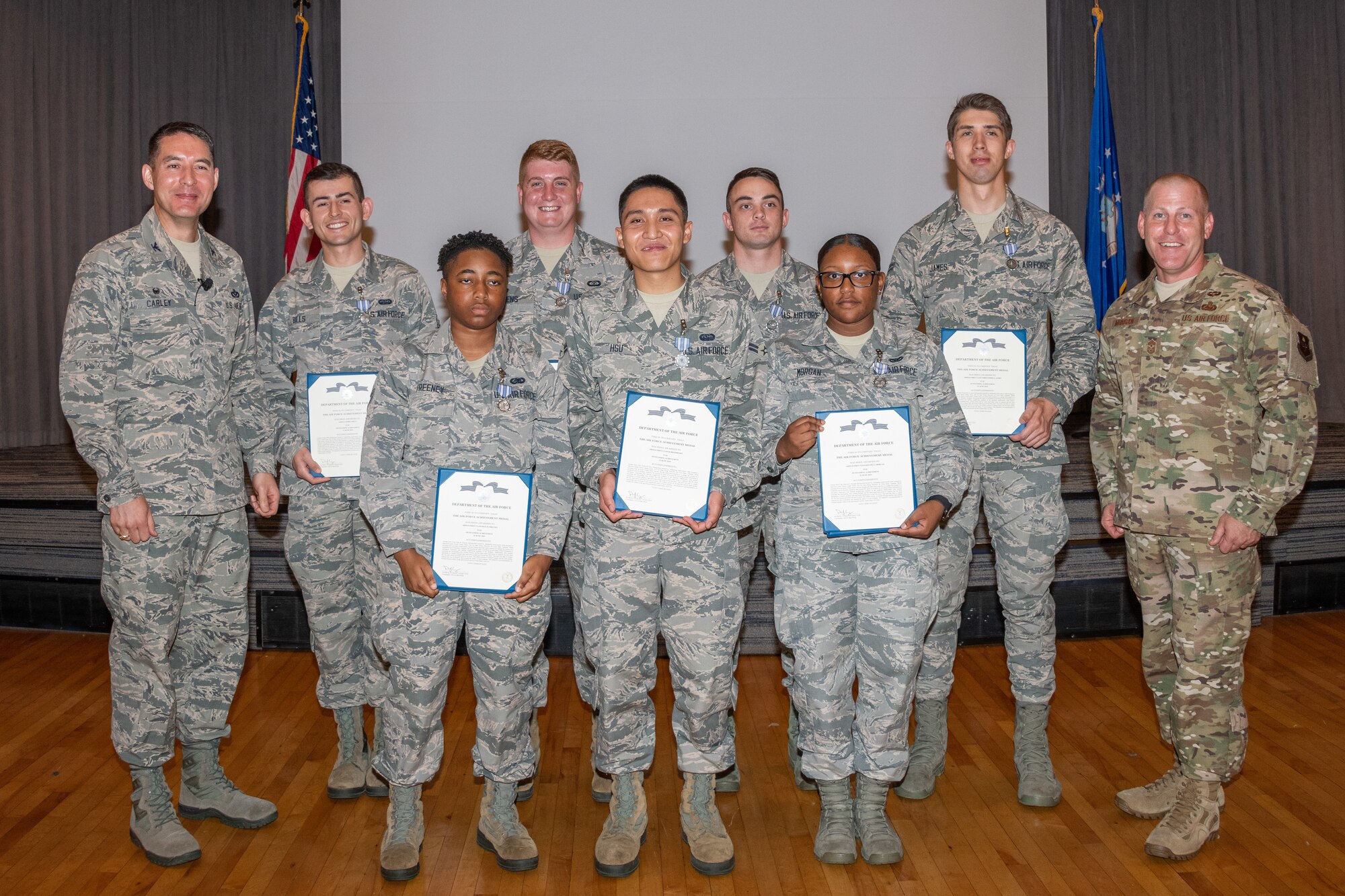 Col. Patrick Carley, 42nd Air Base Wing commander and Chief Master Sgt. Michael Morgan, 42nd ABW command chief, stand on either side of Airman Joshua Bills, Senior Airman Forrest Bivens, Airman 1st Class Brandon Hedelund, Airman 1st Class Christopher James, Airman 1st Class Deja Freeney, Airman 1st Class Kobi Hsu, Airman 1st Class Keivona Morgan, Maxwell Honor Guardsmen, for a group photo after presenting them Air Force Achievement Medals, July 18, 2019, Maxwell Air Force Base, Alabama. The group of Maxwell Honor guardsmen were bestowed the medals for assisting a local woman when her garage suddenly caught fire. (U.S. Air Force photo by Cassandra Cornwall)