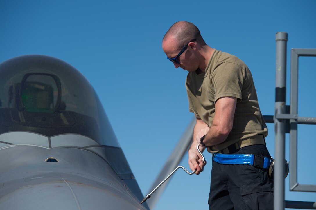 U.S. Air Force Airman 1st Class Dylan Brown, 94th Aircraft Maintenance Unit integrated avionics journeyman, reattaches a panel after performing maintenance on an F-22 Raptor at Nellis Air Force Base, Nevada, July 16, 2019.