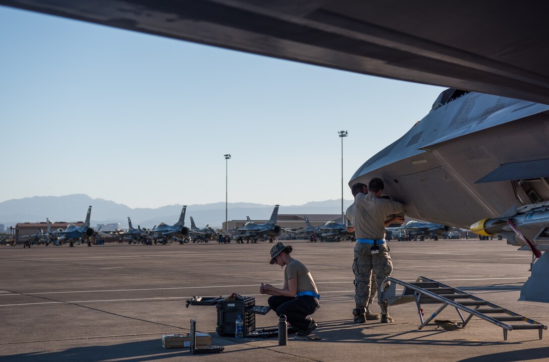 U.S. Air Force integrated avionics specialists from 94th Aircraft Maintenance Unit perform maintenance on an F-22 Raptor at Nellis Air Force Base, Nevada, July 16, 2019.