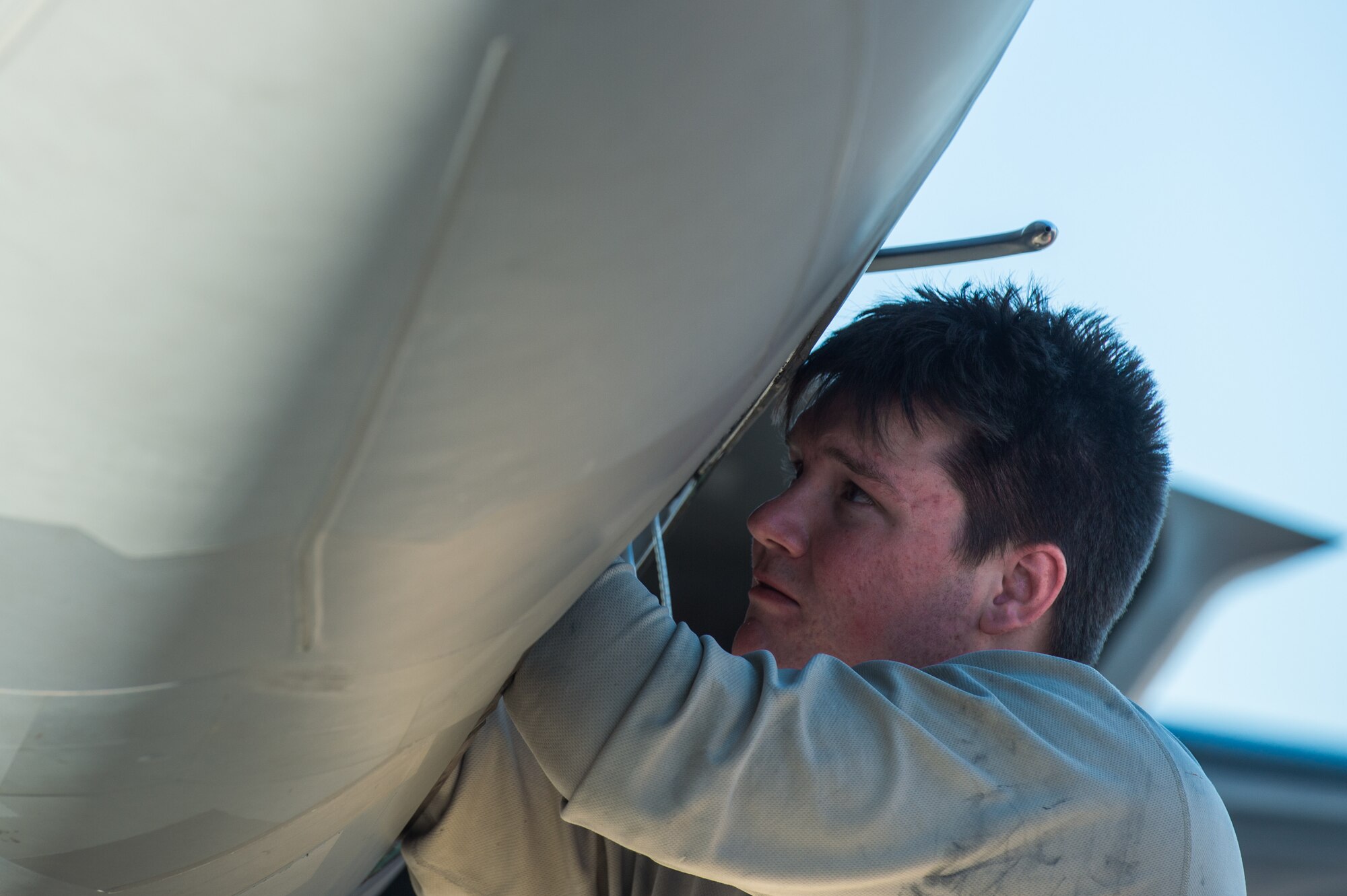 U.S. Air Force Airman 1st Class Zachary Perry, 94th Aircraft Maintenance Unit integrated avionics journeyman, performs maintenance on an F-22 Raptor at Nellis Air Force Base, Nevada, July 16, 2019.