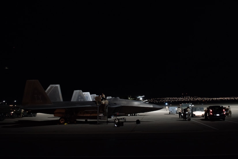 U.S. Air Force integrated avionics specialists from the 94th Aircraft Maintenance Unit perform maintenance on an F-22 Raptor at Nellis Air Force Base, Nevada, July 22, 2019.