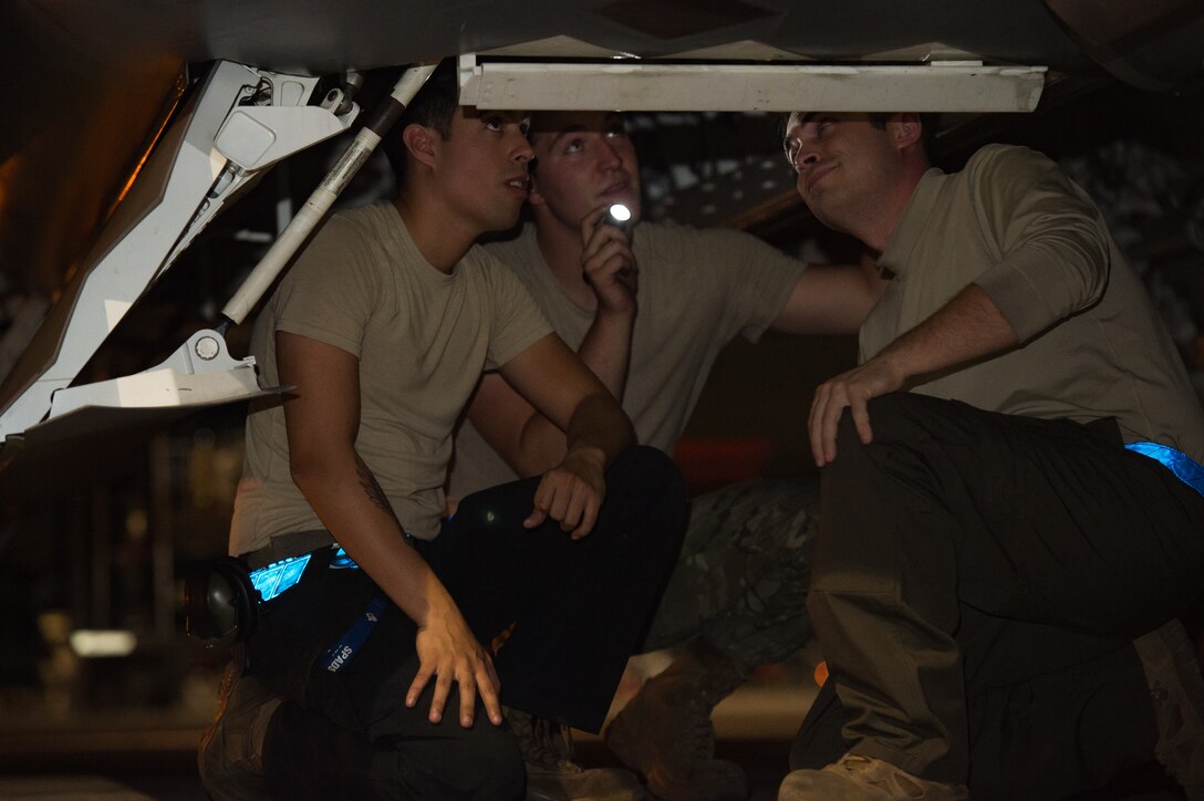 U.S. Air Force integrated avionics specialists from the 94th Aircraft Maintenance Unit perform maintenance on an F-22 Raptor at Nellis Air Force Base, Nevada, July 22, 2019.