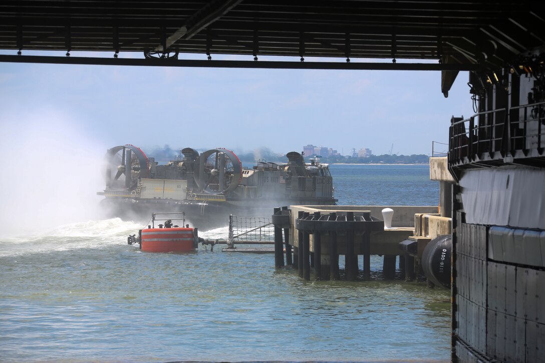 U.S. Navy Landing Craft, Air Cushion 85 departs the dock landing ship USS Carter Hall, after off-loading its cargo during a Marine and Navy joint-loading exercise aboard LSD 50 July 11, 2019 at Naval Station Norfolk, Va. The LOADEX mission is to help Marines and Sailors maintain proficiency, combat readiness, and mission capability. (U.S. Marine Corps photo by Cpl. Desmond Martin)