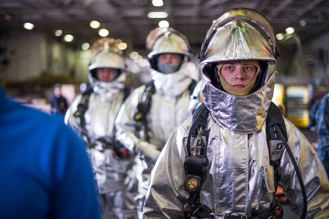 Aviation boatswain’s mate (handling) prepares to enter simulated casualty environment while wearing “hot suit” in USS John C. Stennis’s hangar bay
during general quarters drill, Bremerton, Washington, July 27, 2017 (U.S. Navy/Luke Moyer)