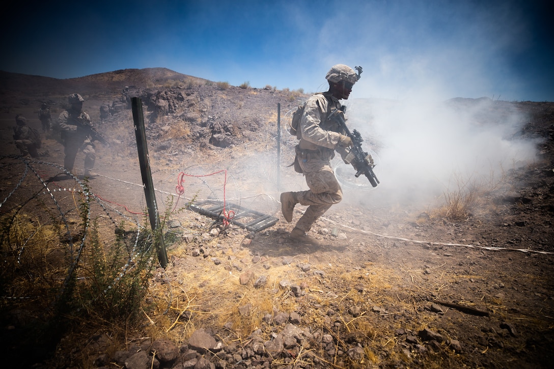 U.S. Marine Corps Pfc. Trevor M. Banks, fireteam leader, Company I, 3rd Battalion, 7th Marine Regiment, 1st Marine Division, moves through a breach to attack an objective during a squad attack at Marine Corps Air Ground Combat Center, Twentynine Palms, Calif., July 15, 2019. The training was conducted to validate the squad leaders capabilities to lead and control their squads while integrating supporting arms in a deliberate attack.