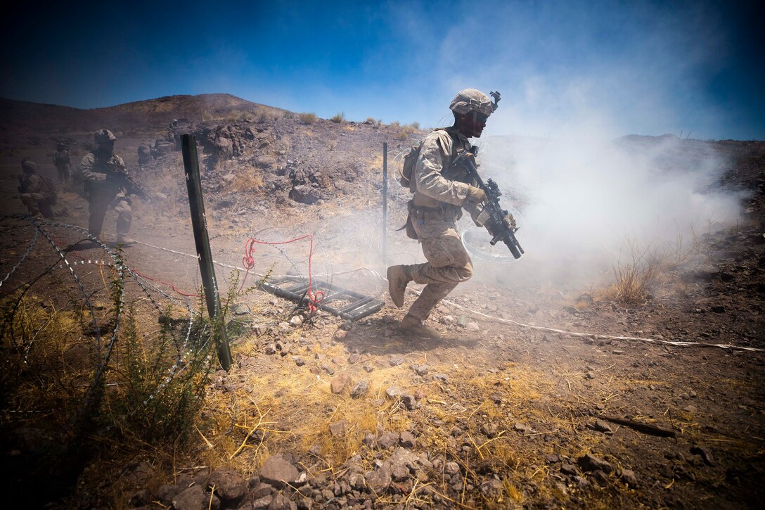 A Marine runs while holding a weapon.