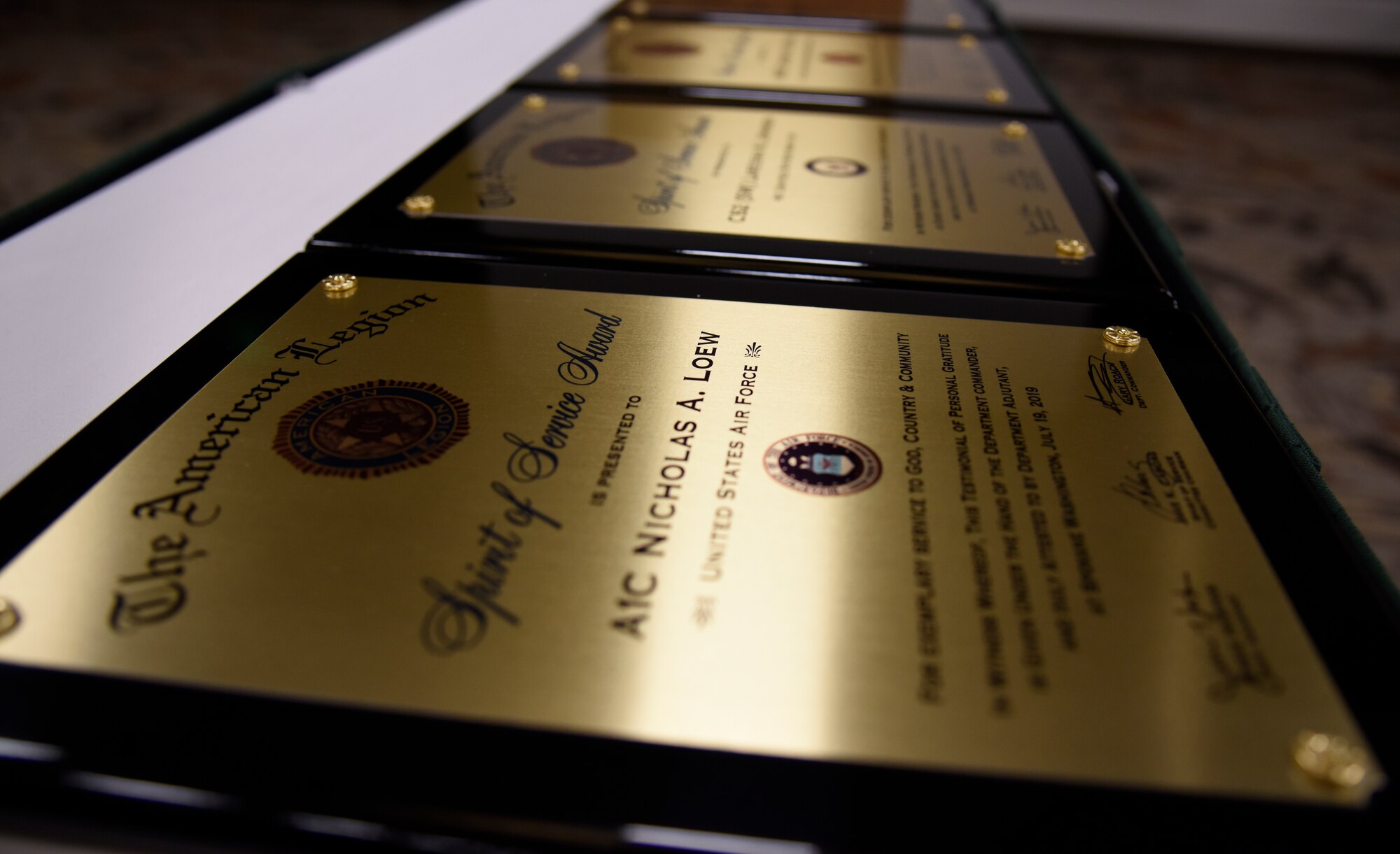 Spirit of Service Award plaques are displayed on a table during the annual American Legion Department Convention in Spokane, Washington, July 19, 2019. The Legion gives the Spirit of Service Awards annually to members from each branch who excel in their performance on-duty and are also actively involved in their local community. (U.S. Air Force photo by Senior Airman Jesenia Landaverde)