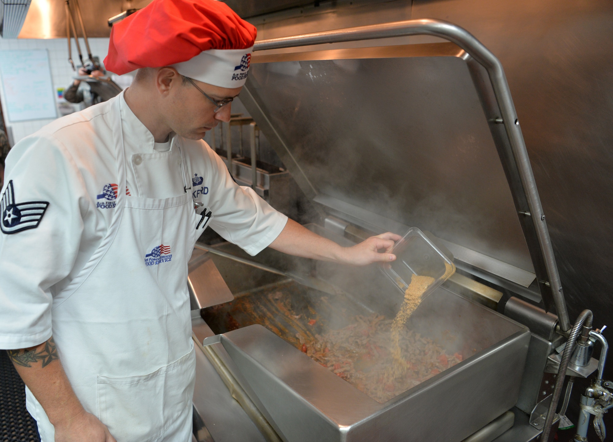 Staff Sgt. Daniel Bickford, 99th Force Support Squadron food service craftsman, adds seasoning to a dish for service members on temporary duty to Red Flag 19-3 at Nellis Air Force Base, Nev., July 18, 2019. Red Flag was established in 1975 to better prepare our forces for combat. Lessons from Vietnam showed that if a pilot survived ten combat missions, his chances of surviving remaining missions increased significantly. (U.S. Air Force photo by Tech. Sgt. Bryan Magee)