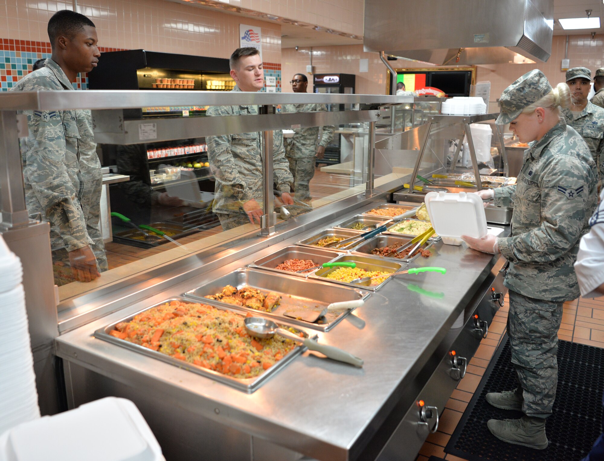 Airman 1st Class Riley, 319th Force Support Squadron food service journeyman, Grand Forks AFB, N.D., serves lunch for service members during Red Flag 19-3 at Nellis Air Force Base, Nev., July 18, 2019. Red Flag was established in 1975 to better prepare our forces for combat. Lessons from Vietnam showed that if a pilot survived 10 combat missions, his chances of surviving remaining missions increased significantly. (U.S. Air Force photo by Tech. Sgt. Bryan Magee)