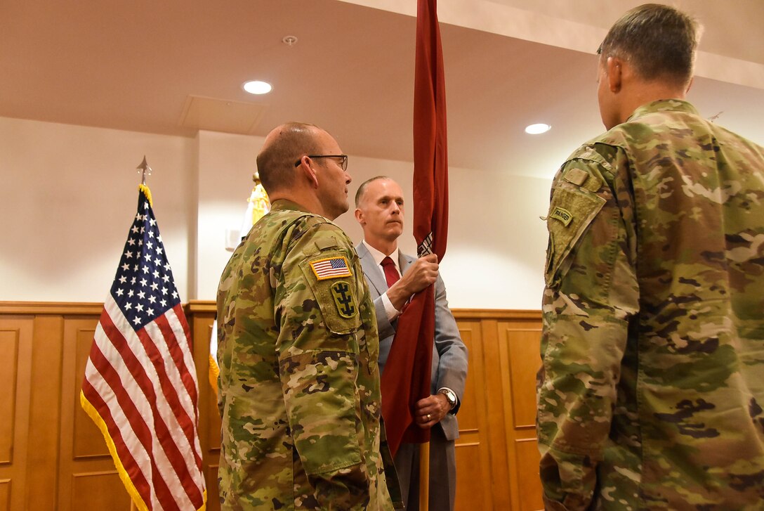 Col. Christopher Crary, U.S. Army Corps of Engineers (USACE), Far East District (FED) commander, passes the district colors to Richard Byrd, deputy district engineer, during a change of command ceremony held at River Bend Golf Course, Camp Humphreys, South Korea, July 24.