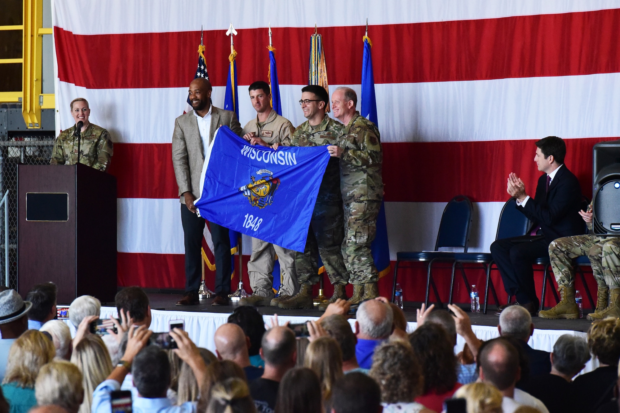 Wisconsin Lt. Gov. Mandela Barnes and U.S. Air Force Maj. Gen. Donald Dunbar, the adjutant general of Wisconsin, present the Wisconsin flag to Lt. Col. Tim Dyer and Maj. Scott Paeth, both deploying Airmen of the 115th Fighter Wing, at a send off ceremony held at Truax Field, Madison, Wis. on July 21, 2019.  The 115th Fighter Wing deployed approximately 300 personnel and a number of aircraft to Afghanistan in support of Operation Freedom Sentinel and NATO's Resolute Support. (U.S. Air National Guard photo by Staff Sgt. Kyle Russell)