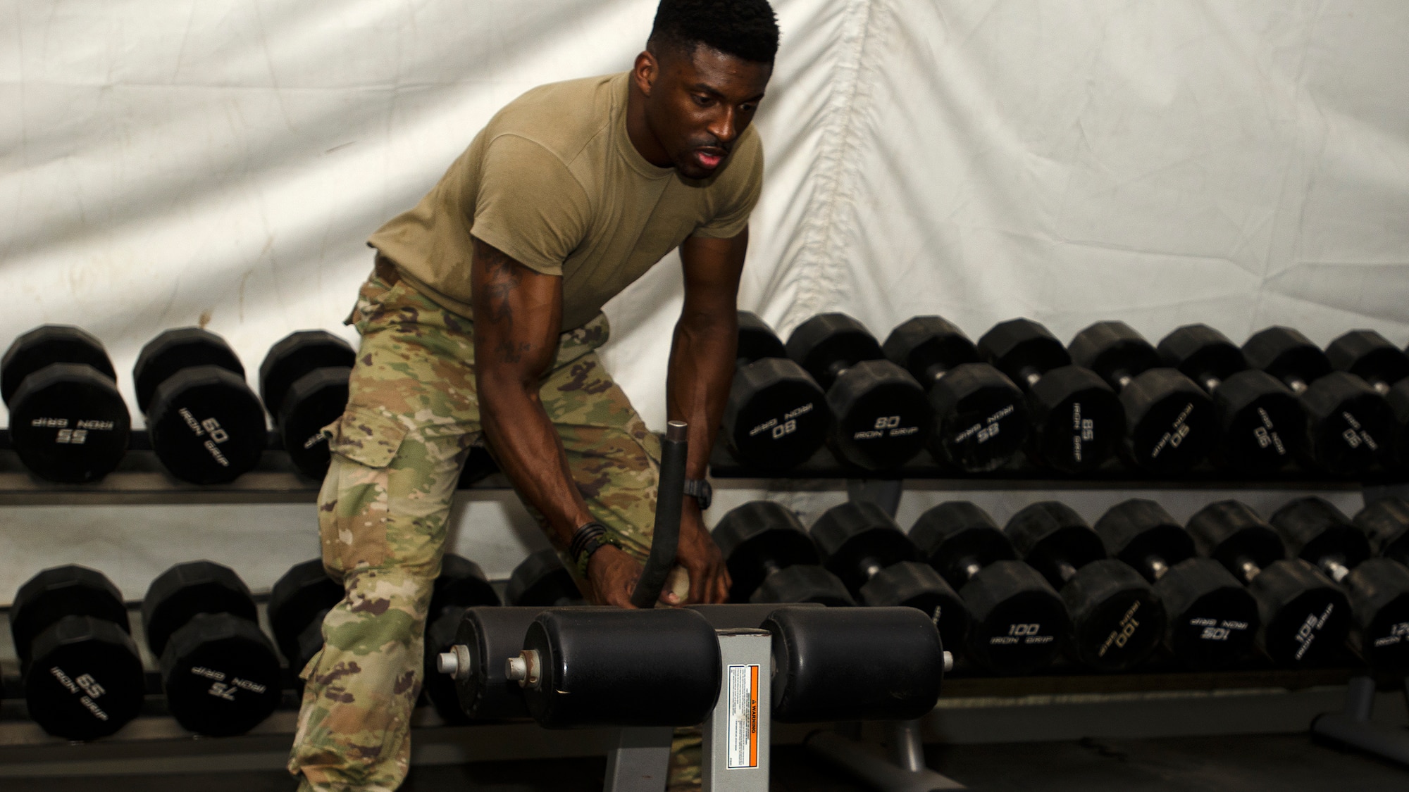 U.S. Air Force Master Sgt. Alonza Loury, 386th Expeditionary Force Support Squadron, moves workout equipment in the new fitness tent on Ali Al Salem Air Base, Kuwait, July 24, 2019. The new fitness tent is slated to open Aug.1, 2019, replacing the original facility which is scheduled for demolition to make room for future base improvement projects. This facility offers Airmen a second fitness location and expected to be in use until mid-November when the more permanent structure is completed. (U.S. Air Force photo by Capt. Stephen Hudson)