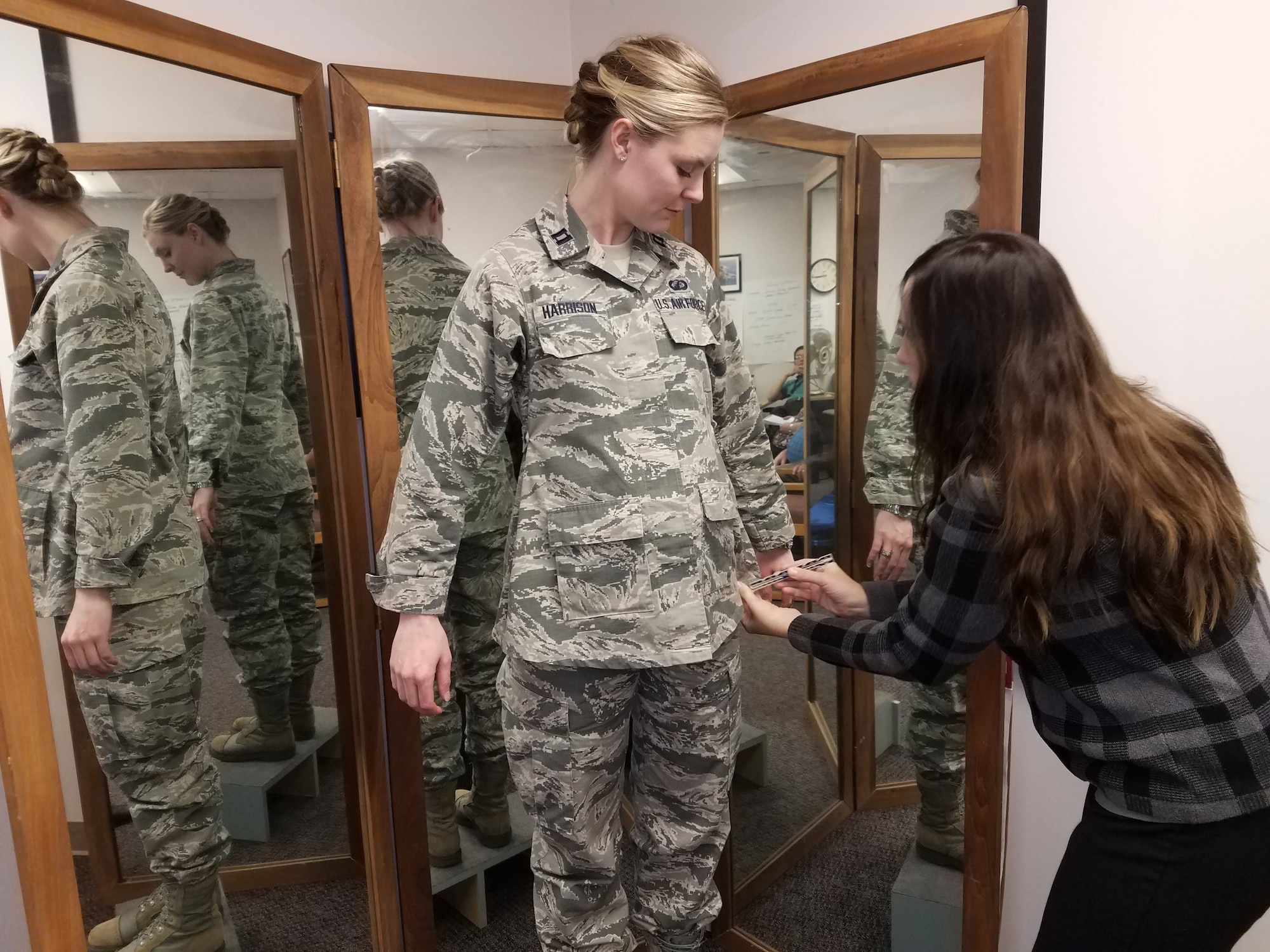 Stacey Butler (right) a clothing designer with the Air Force Life Cycle Management Center's Air Force Uniform Office, measures Capt. Taylor Harrison's maternity Airman Battle Uniform. The new uniforms were designed and developed by the office and are available to pregnant Airmen around the world.