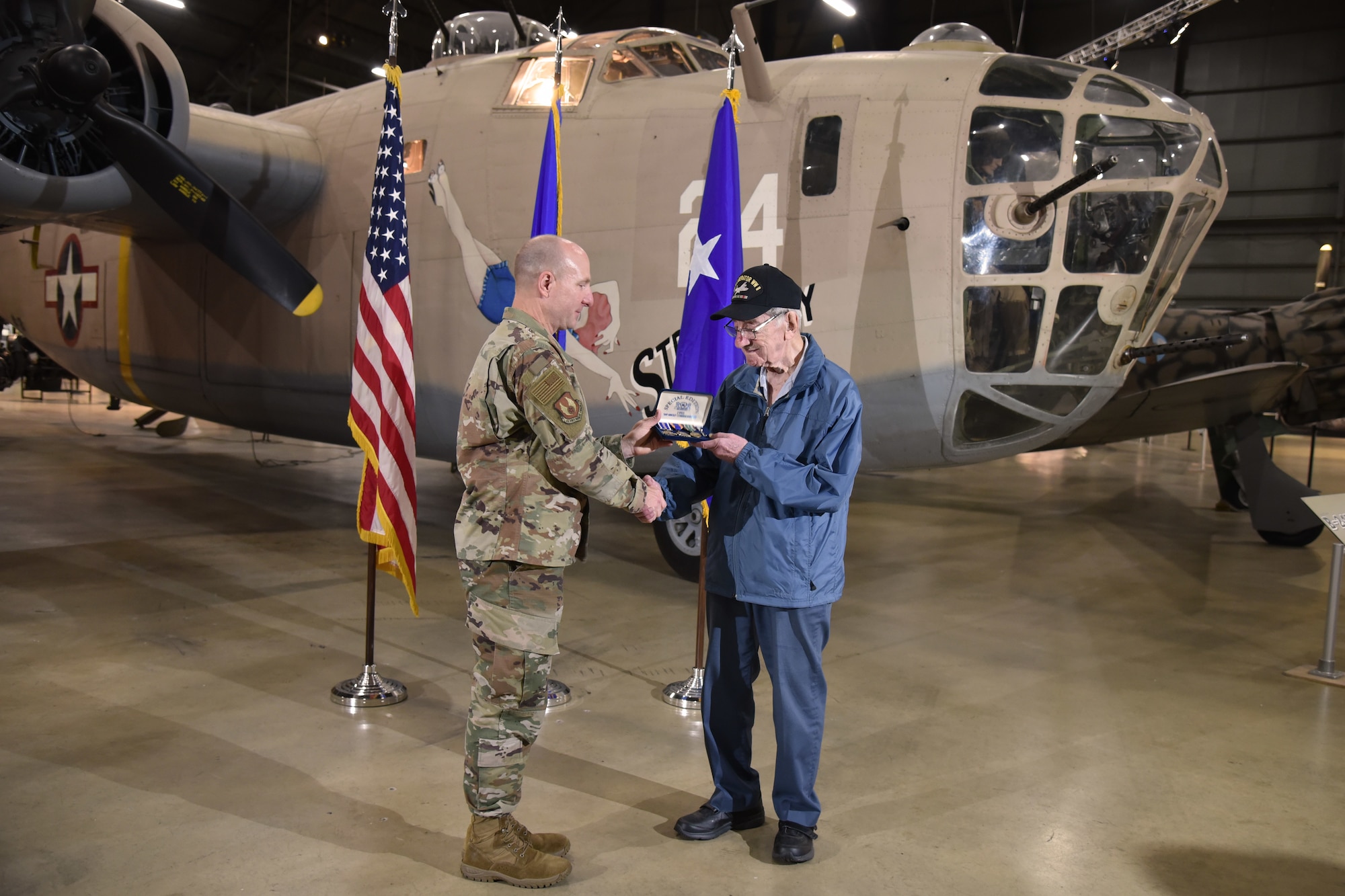 Maj. Gen. Carl Schaefer, Air Force Materiel Command deputy commander, presents service medals to 93-year-old World War II veteran 1st Lt. Joseph Kollenberg at the National Museum of the United States Air Force, July 24. Schaefer presented Kollenberg with the  Distinguished Flying Cross, the Air Medal with three Oak Leaf Clusters, and the European, African, and Middle Eastern campaign service medals to replace those misplaced in the 70 years since the veteran left active duty service. (Air Force photo/Ken LaRock)