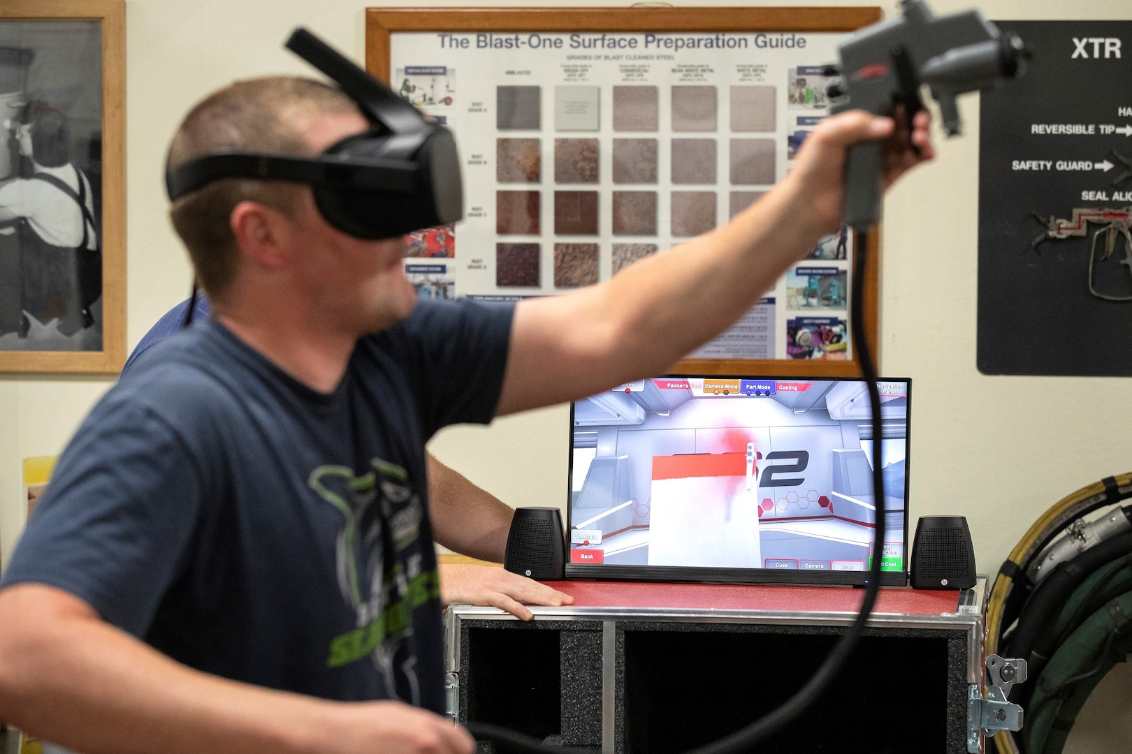 Travis McGreger, Shop 71, Painters, Blasters and Tilesetters, training instructor, demonstrates how the virtual reality paint sprayer trainer works July 10, 2019, in a Continuous Training and Development classroom in Building 460.