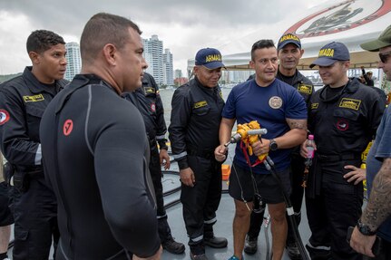 U.S. and Colombian navy personnel speak in group.