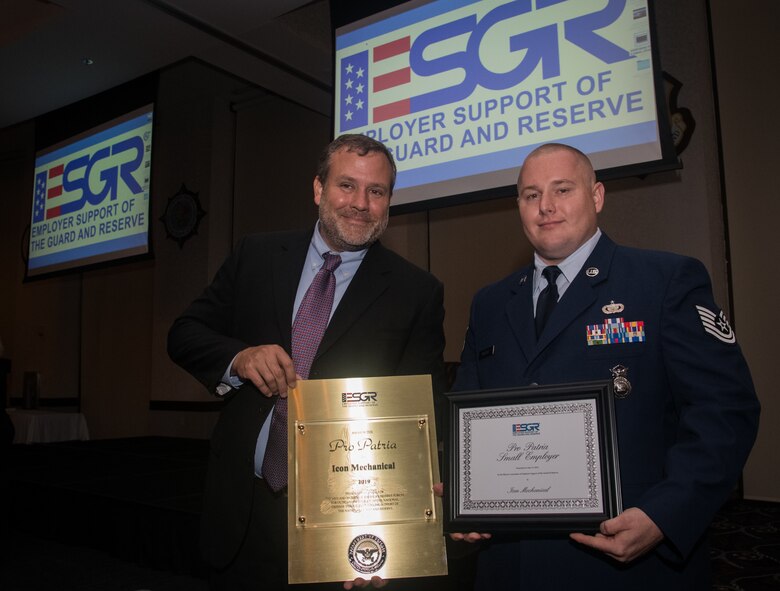 Mr. Jeffery Rush, with Icon Mechanical, and Tech. Sgt. Christopher Wallace, 932nd Airlift Wing Security Forces Squadron defender display awards received during the Employer Support of the Guard and Reserve award banquet, July 19, 2019, Scott Event Center, Scott Air Force Base, Illinois.  Wallace shared that he has worked with Icon Mechanical for almost as long as he’s been at the 932nd AW and that he nominated his employer for an ESGR award for the outstanding support provided to him and his family during multiple deployments and time away. (U.S. Air Force photo by Christopher Parr)