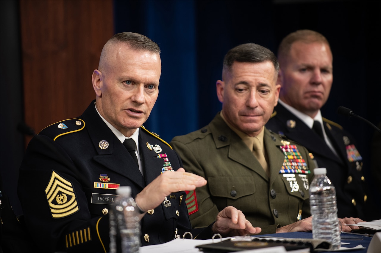 Man on panel speaks.