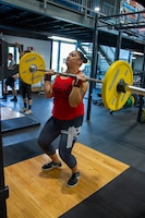 Staff Sgt. Lisa Owens, senior financial management analyst, 1st Theater Sustainment Command (TSC), lifts a loaded barbell to an overhead position during her training for the 1,000-pound  club at Otto Fitness Center at Fort Knox, Ky., July 17, 2019.