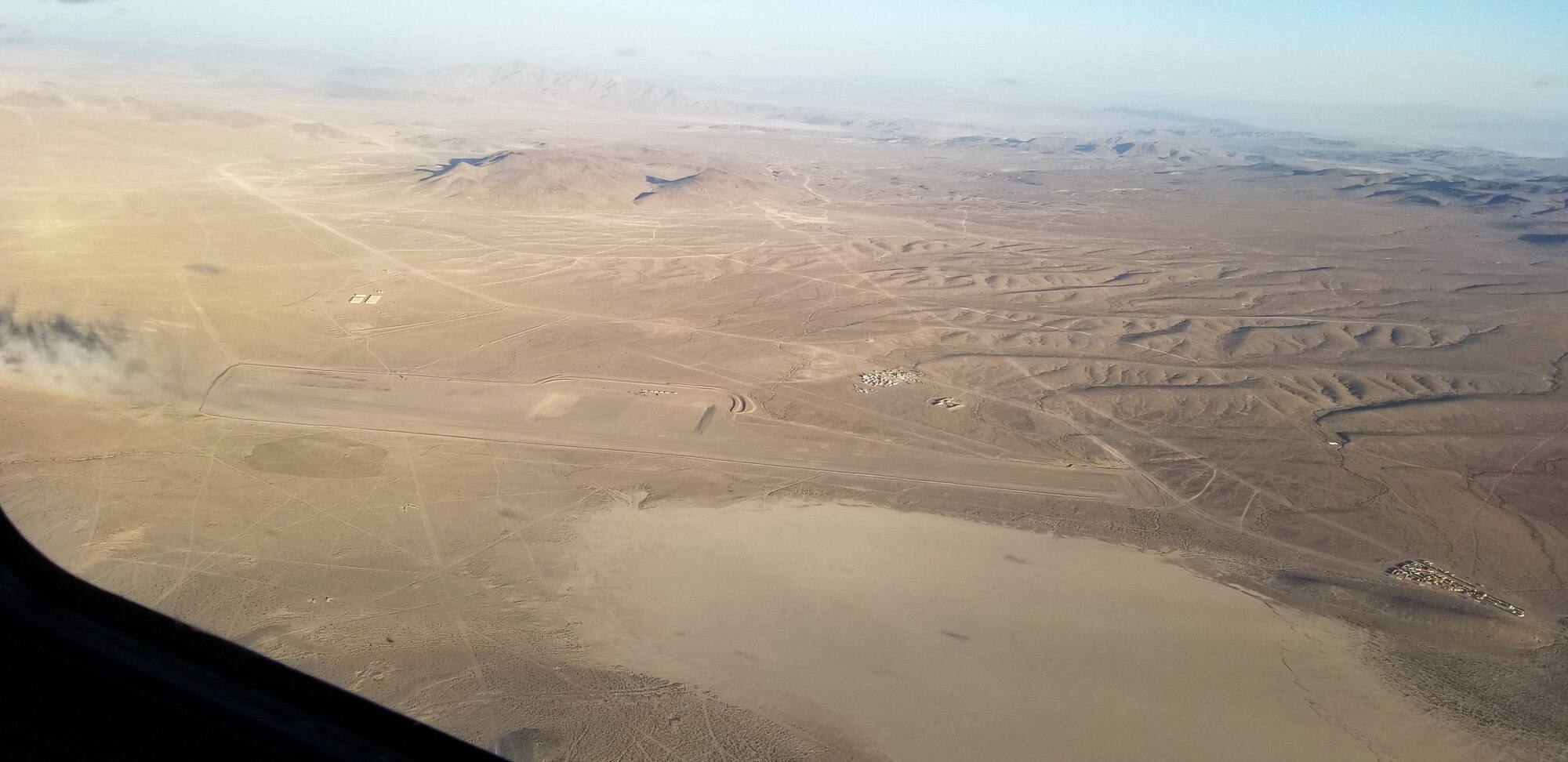 Maj. Dennis Martin, 225th Air Defense Squadron air battle manager, watches as the C-17 he is flying in during Exercise Rainier War approaches Bicycle Lake Army Air Field near Fort Irwin, California, June 26, 2019.  Martin is one of four air battle managers flying onboard the C-17s during the exercise in order to accomplish a portion of his training requirements to convert to a rated air battle manager.  (Courtesy Photo by Maj. Dennis Martin)