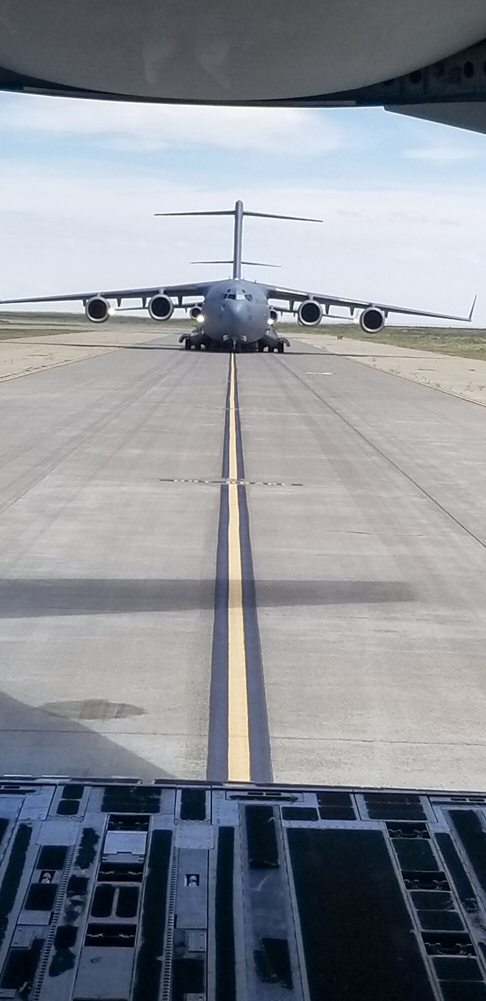 Maj. Dennis Martin, 225th Air Defense Squadron air battle manager, watches from the back of the C-17 he is flying in during Exercise Rainier War as four C-17s simulate dropping off cargo at Mountain Home Air Force Base, Idaho, June 26, 2019.  Martin is one of four air battle managers flying onboard the C-17s during the exercise in order to accomplish a portion of his training requirements to convert to a rated air battle manager.  (Courtesy Photo by Maj. Dennis Martin)