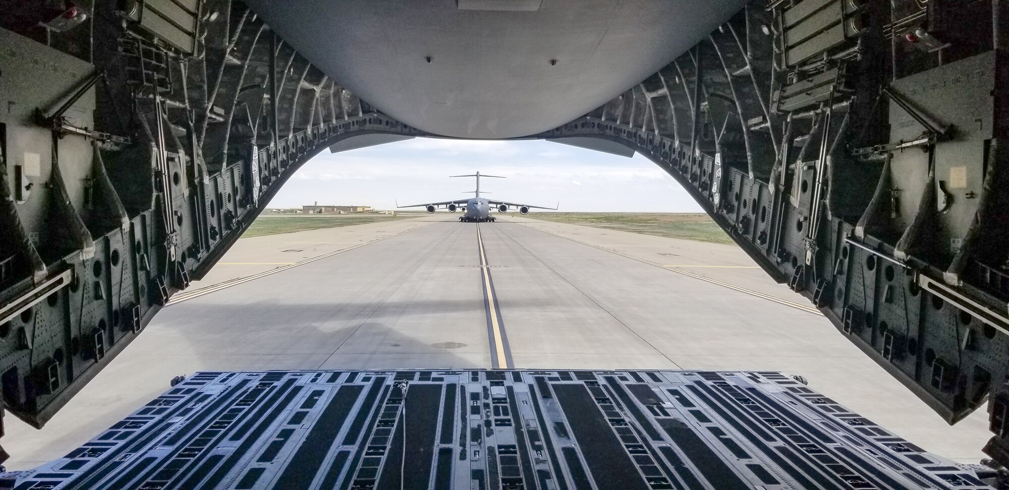 Maj. Dennis Martin, 225th Air Defense Squadron air battle manager, watches from the back of the C-17 he is flying in during Exercise Rainier War as four C-17s simulate dropping off cargo at Mountain Home Air Force Base, Idaho, June 26, 2019.  Martin is one of four air battle managers flying onboard the C-17s during the exercise in order to accomplish a portion of his training requirements to convert to a rated air battle manager.  (Courtesy Photo by Maj. Dennis Martin)
