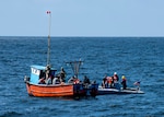 A man boards a ship via a ladder.