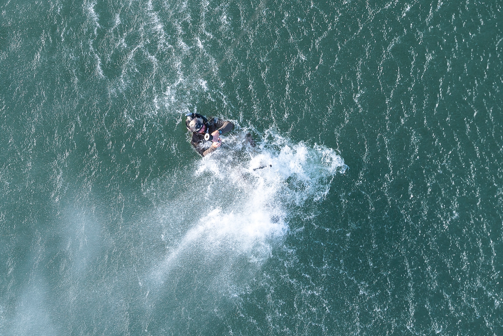 Staff Sgt. Joe, 26th Special Tactics Squadron pararescuman, prepares to be hoisted from the water at Ute Lake, N.M., July 23, 2019. The training focused on water-based aerial extraction with members of the 20th Special Operations Squadron. (U.S. Air Force photo by Senior Airman Vernon R. Walter III)