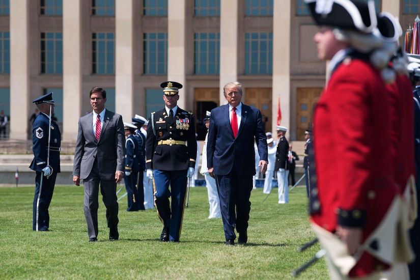President Donald J. Trump and Defense Secretary Dr. Mark T. Esper walk by troops on the Pentagon lawn.