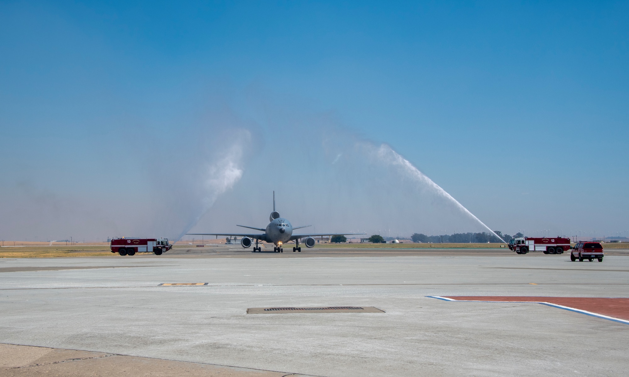 Fire trucks spray water over a KC-10 Extender piloted by Col. Theresa Weems, 60th Operations Group commander, after her final flight, July 24, 2019, at Travis Air Force Base, California. The flight, which is a military tradition, served as an opportunity for the Travis community to honor Weems and wish her well on her next assignment. Weems has served as the commander for the 60th OG for the largest air mobility wing in the Air Force since July 2017. (U.S. Air Force photo by Heide Couch)