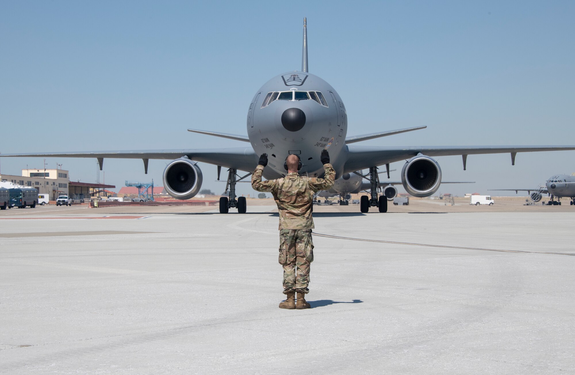A U.S. Air Force ground maintenance crew member marshals in a KC-10 Extender piloted by Col. Theresa Weems, 60th Operations Group commander, during her final flight, July 24, 2019, at Travis Air Force Base, California. The flight, which is a military tradition, served as an opportunity for the Travis community to honor Weems and wish her well on her next assignment. Weems has served as the commander for the 60th OG for the largest air mobility wing in the Air Force since July 2017. (U.S. Air Force photo by Heide Couch)
