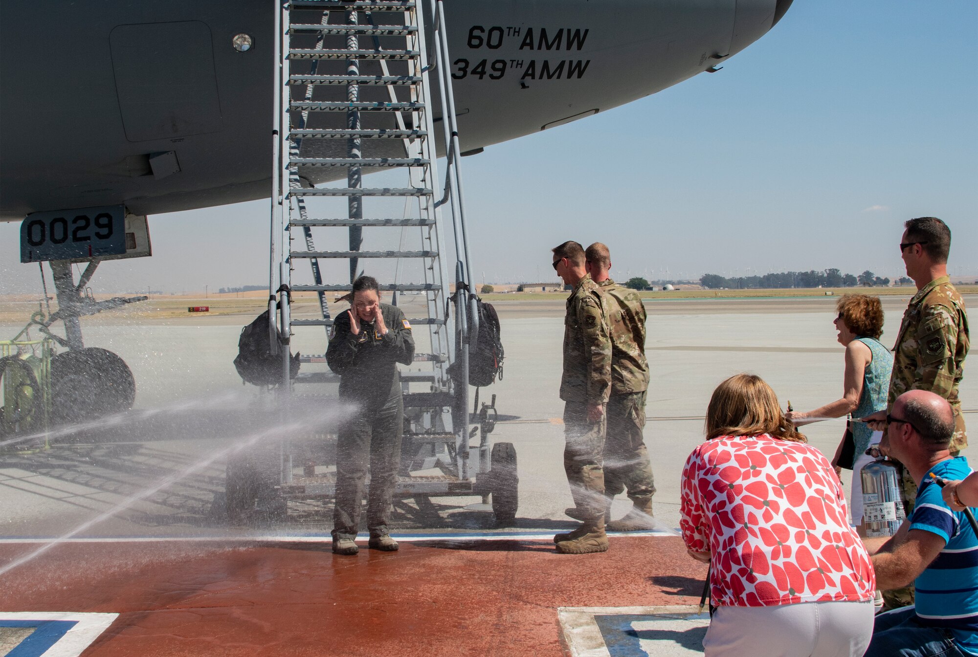 U.S. Air Force Col. Theresa Weems, 60th Operations Group commander, gets doused after her final flight at Travis Air Force Base, California, July 24, 2019. Fini-flights are a traditional way to mark milestones in the career of aircrew, respected individuals of rank or repute, or a commander's departure to another command. Weems has served as the commander for the 60th OG for the largest air mobility wing in the Air Force since July 2017. (U.S. Air Force photo by Heide Couch)