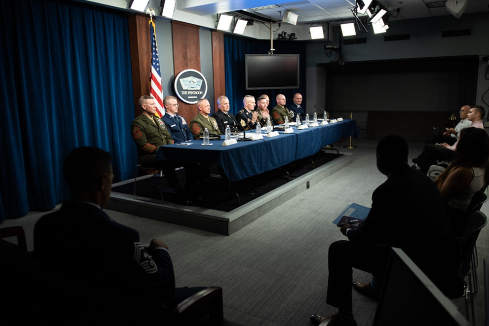 Man on panel speaks.