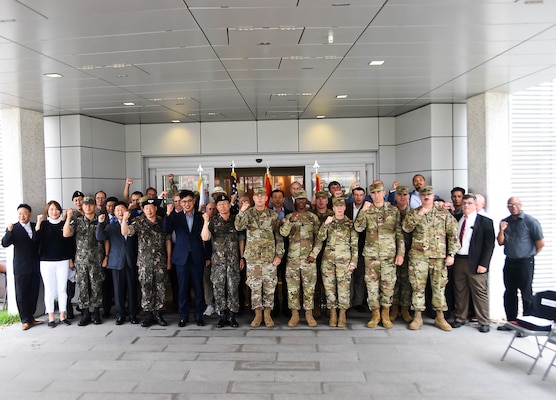 Brig. Thomas Tickner (center), U.S. Army Corps of Engineers (USACE), Pacific Ocean Division commander, and dignitaries gather in front of the new Brian D. Allgood Army Community Hospital, following the signing of the Acceptance Release Letter, Camp Humphreys, South Korea, July 24. (Photos by Antwaun J. Parrish)