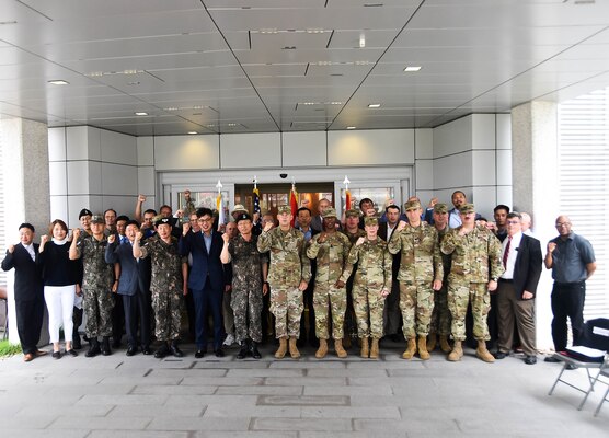 Brig. Thomas Tickner (center), U.S. Army Corps of Engineers (USACE), Pacific Ocean Division commander, and dignitaries gather in front of the new Brian D. Allgood Army Community Hospital, following the signing of the Acceptance Release Letter, Camp Humphreys, South Korea, July 24. (Photos by Antwaun J. Parrish)