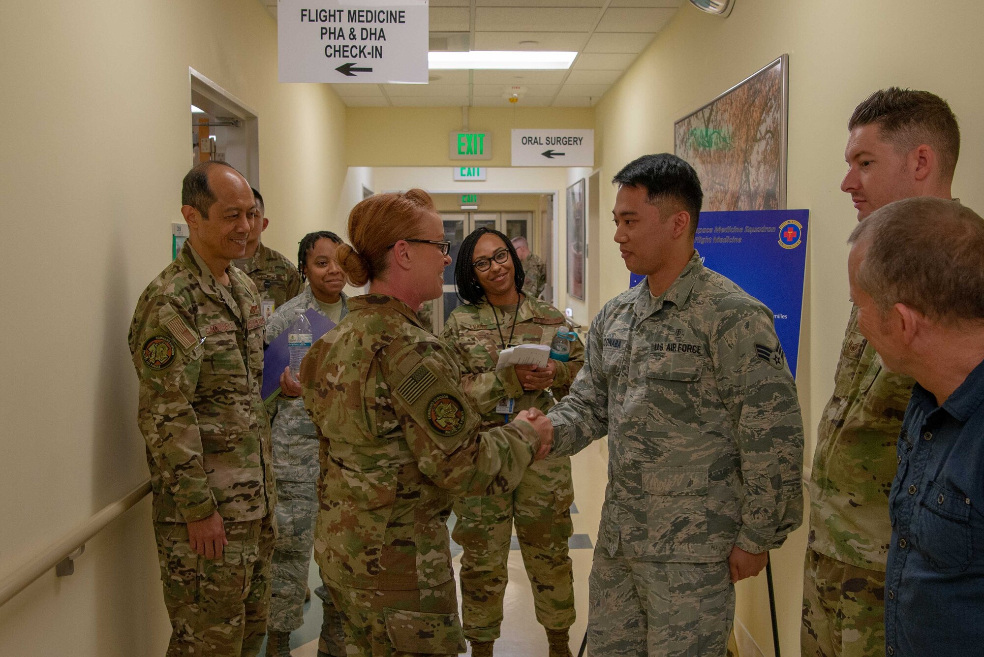 Members of the 374th Medical Group look on as Chief Master Sgt. Yvonne Shaw, Pacific Air Forces Medical Enlisted Force Chief, coins Senior Airman Dionel Alconaba, a public health technician at flight medicine, for his excellent work at Yokota AB, Japan’s Flight Medicine office. Shaw visited the 374th Medical Group to meet the personnel and recognize outstanding performers.