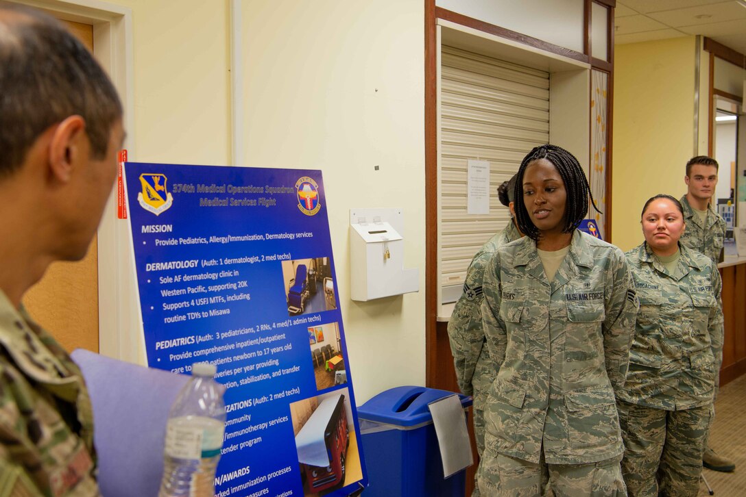 Senoir Airman Shante Burks breaks down Yokota AB, Japan’s immunization operations to Col. Rudolph Cachuela, July 23, 2019. Cachuela visited the 374th Medical Group to better understand how his team can increase the effectiveness of the medical personnel at Yokota.