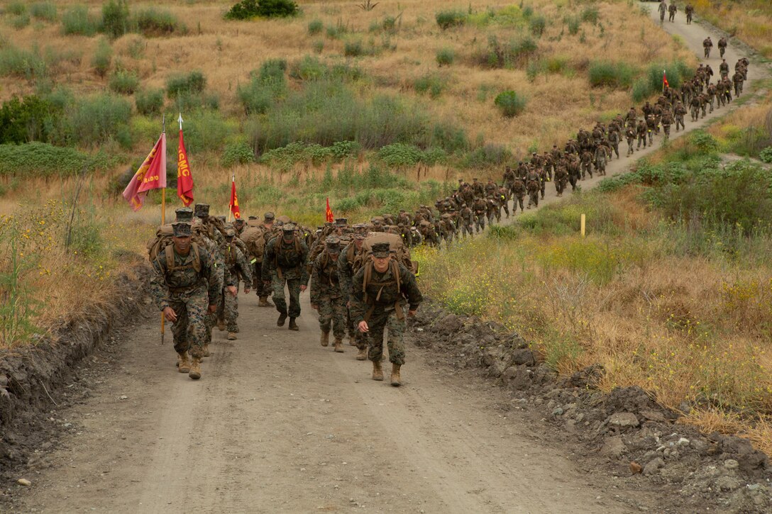 U.S. Marine Lt. Col. Duane Durant, commanding officer, 1st Radio Battalion, I Marine Expeditionary Force Information Group (I MIG) and Sgt. Maj. Sael Garcia, sergeant major, 1st Radio Battalion, I MIG, lead a battalion hike on Marine Corps Base Camp Pendleton, June 21, 2019. The Marines hiked 9 miles carrying school supplies to donate, averaging 16 pounds of supplies per Marine, in addition to their combat load. (U.S. Marine Corps photo by Pfc. Issac Velasco)