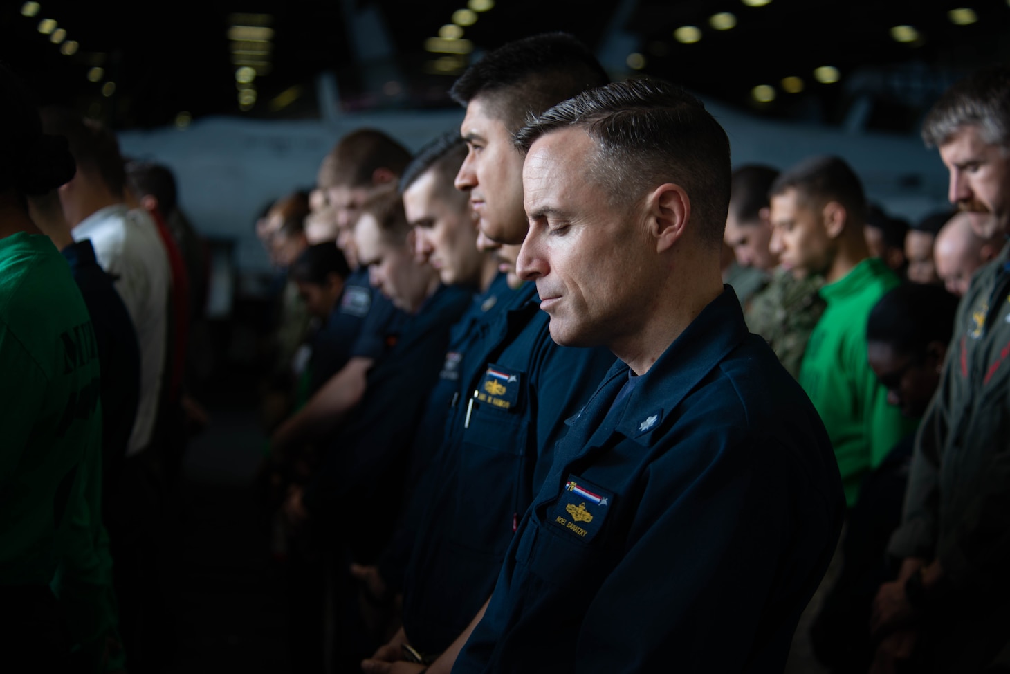CORAL SEA (July 26, 2019) Sailors observe a moment of silence in the hangar bay aboard the Navy’s forward-deployed aircraft carrier USS Ronald Reagan (CVN 76) during a remembrance ceremony for USS Lexington (CV 2). Ronald Reagan is the first aircraft carrier to commemorate Lexington since the discovery of the wreckage in 2018. Ronald Reagan, the flagship of Carrier Strike Group 5, provides a combat-ready force that protects and defends the collective maritime interests of its allies and partners in the Indo-Pacific region.