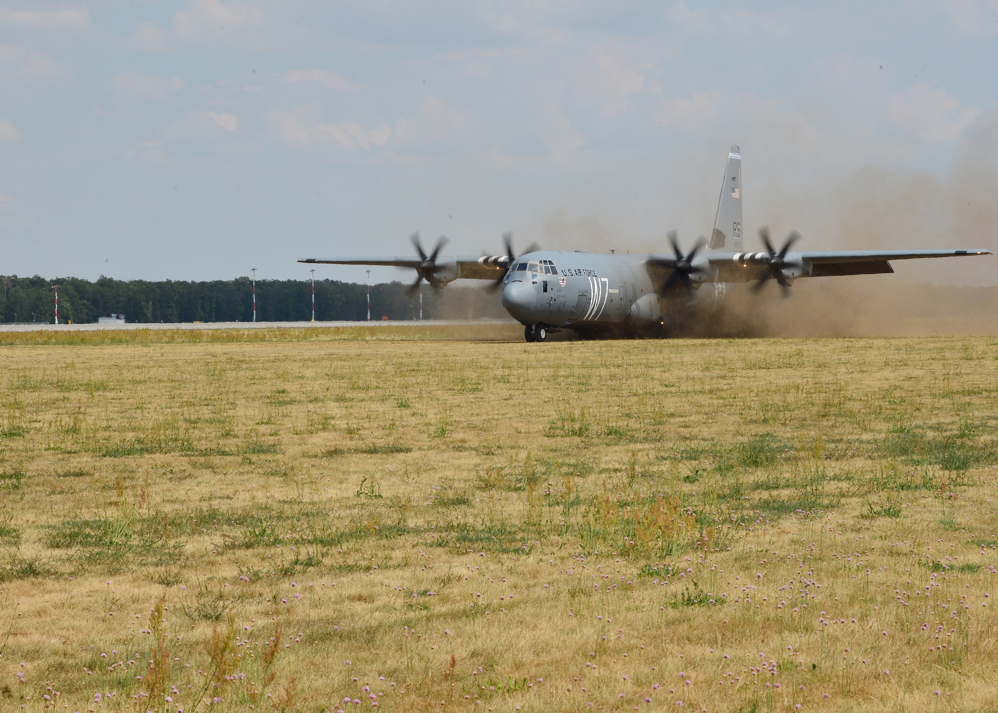 A U.S. Air Force C-130J Super Hercules assigned to the 37th Airlift Squadron lands on a grass landing zone at Powidz Air Base, Poland, July 20, 2019. Pilots were able to practice landing on unpaved surfaces to improve their capabilities and readiness. (U.S. Air Force photo by Staff Sgt. Jimmie D. Pike)