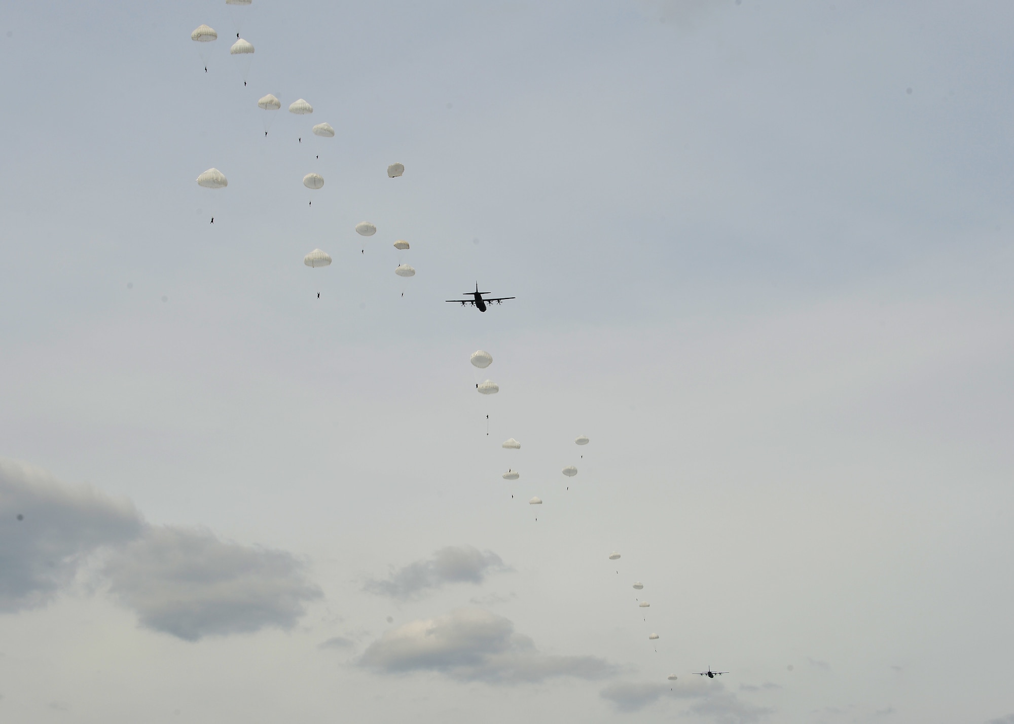 Polish paratroopers jump from U.S. Air Force C-130J Super Hercules aircraft over a drop zone in Poland, July 22, 2019. U.S. and Poland worked on interoperability during Aviation Rotation 19-3, a bilateral exercise aimed at improving partnership capacity, by performing aerial operations over Poland. (U.S. Air Force photo by Staff Sgt. Jimmie D. Pike)