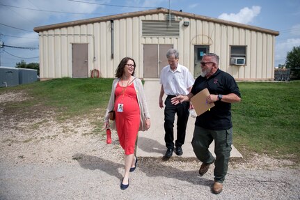 Melissa Little, 59th Medical Wing behavioral health preventive medicine researcher (left), professor Robert Klesges, and Jerry Britt, 341st Training Squadron adoptions and dispositions coordinator, tour the military working dogs (MWDs) kennel June 26, 2019, at Joint Base San Antonio, Texas.