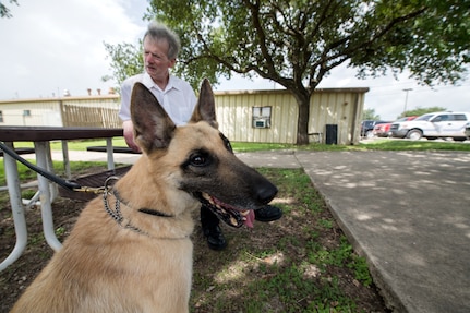Professor Robert Klesges meets with a military working dog (MDW) June 26, 2019, at Joint Base San Antonio, Texas.