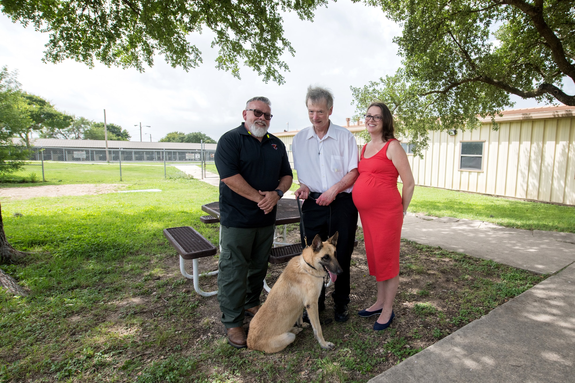 Jerry Britt (left), 341st Training Squadron adoptions and dispositions coordinator, professor Robert Klesges, and Melissa Little, 59th Medical Wing behavioral health preventive medicine researcher, pose for a photo with a military working dog (MWD) June 26, 2019, at Joint Base San Antonio, Texas