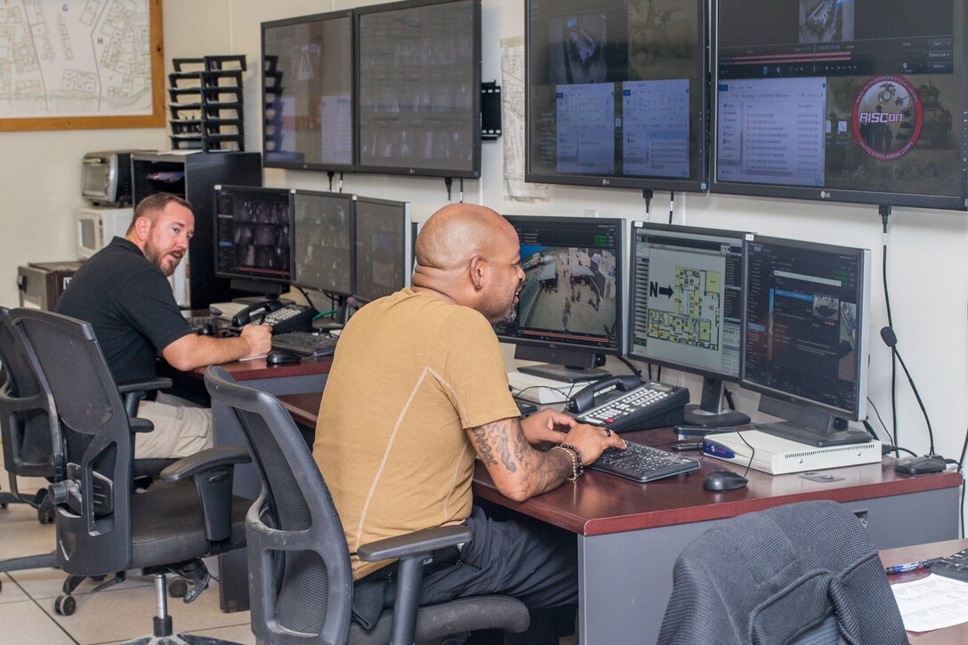 Daniel Slagill, left, a system operator with Training Engineering Support Personnel, Maintenance Training Support Services, Marine Corps Base Camp Pendleton, and Francisco Williams, a system technician with TESP, MTSS, MCB Camp Pendleton, review patrol surveillance footage during a simulated combat patrol at the Infantry Immersion Trainer on Marine Corps Base Camp Pendleton, California, July 23, 2019. The technicians and operators are an essential part of the IIT’s Tactical Video Capture System, a training reviewing system used by infantry Marines and their leadership to enhance after action reviews and increase the unit's ability to make corrections to their patrolling tactics, techniques and procedures. (U.S. Marine Corps photo by Lance Cpl. Drake Nickels)