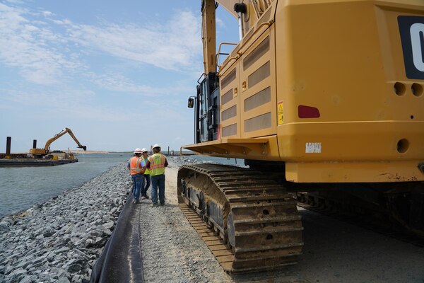 U.S. Army Corps of Engineers, Baltimore District employees Sean Fritzges, a construction representative, and Katie Perkins, a civil engineer, discuss Poplar Island expansion construction progress with a contractor on-site of the expansion July 11, 2019.