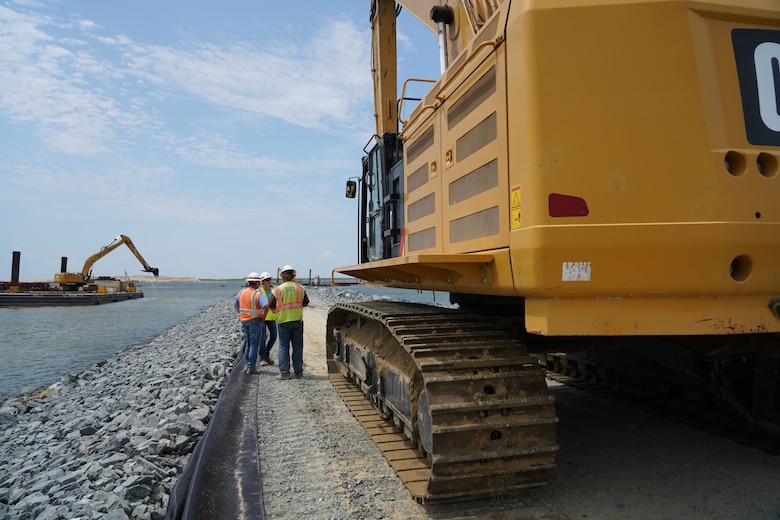 U.S. Army Corps of Engineers, Baltimore District employees Sean Fritzges, a construction representative, and Katie Perkins, a civil engineer, discuss Poplar Island expansion construction progress with a contractor on-site of the expansion July 11, 2019.