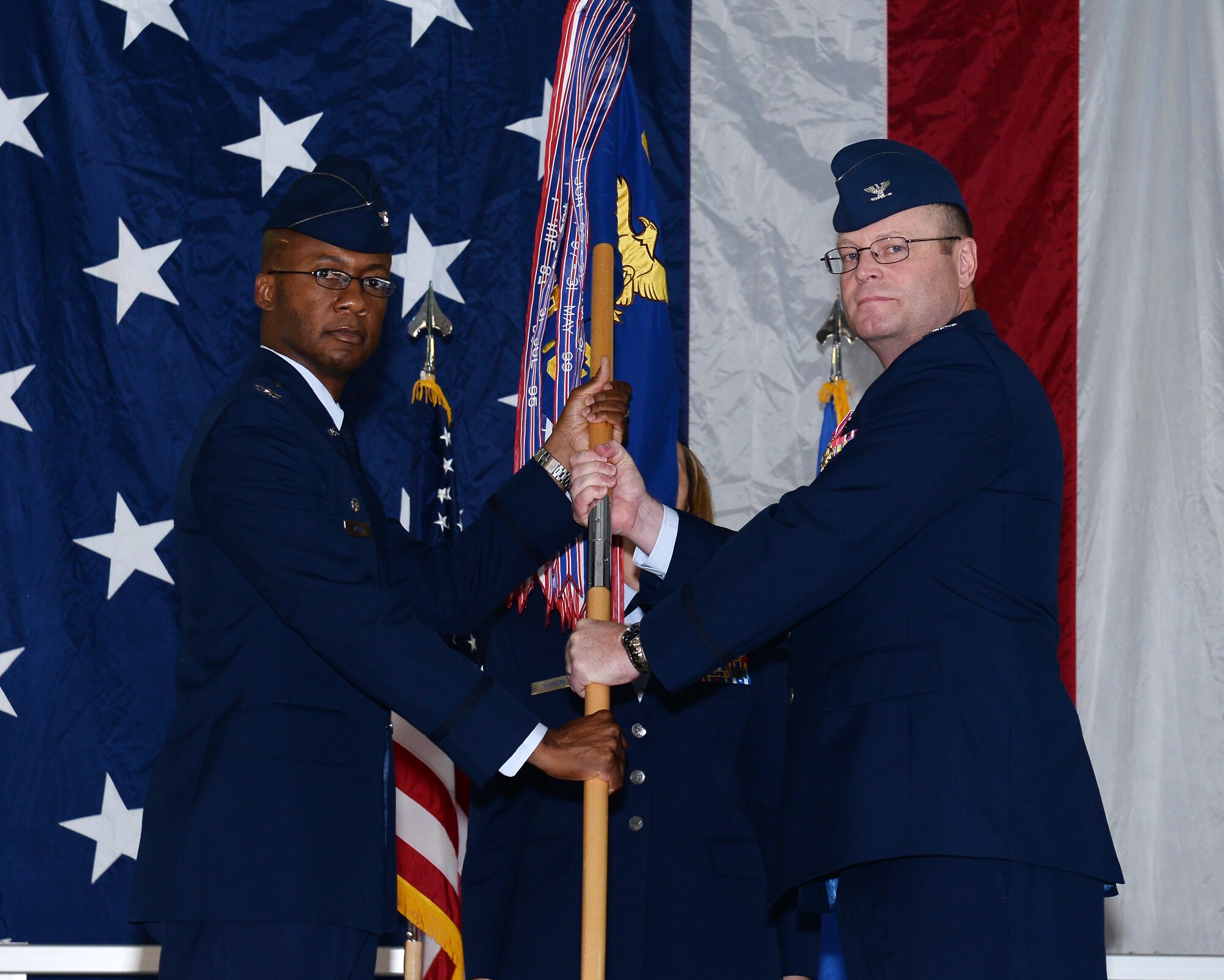 Col. Gavin Marks, 55th Wing commander, receives the 55th Mission Support Group guidon from Col. J. David Norton, during the 55th Mission Support Group Change of Command ceremony July 24, 2019, inside the Offutt Air Force Base Fire Station. Col. W.R. Alan Dayton took over command of the 55th MSG from Col. J. David Norton who has served in the position since 2017.