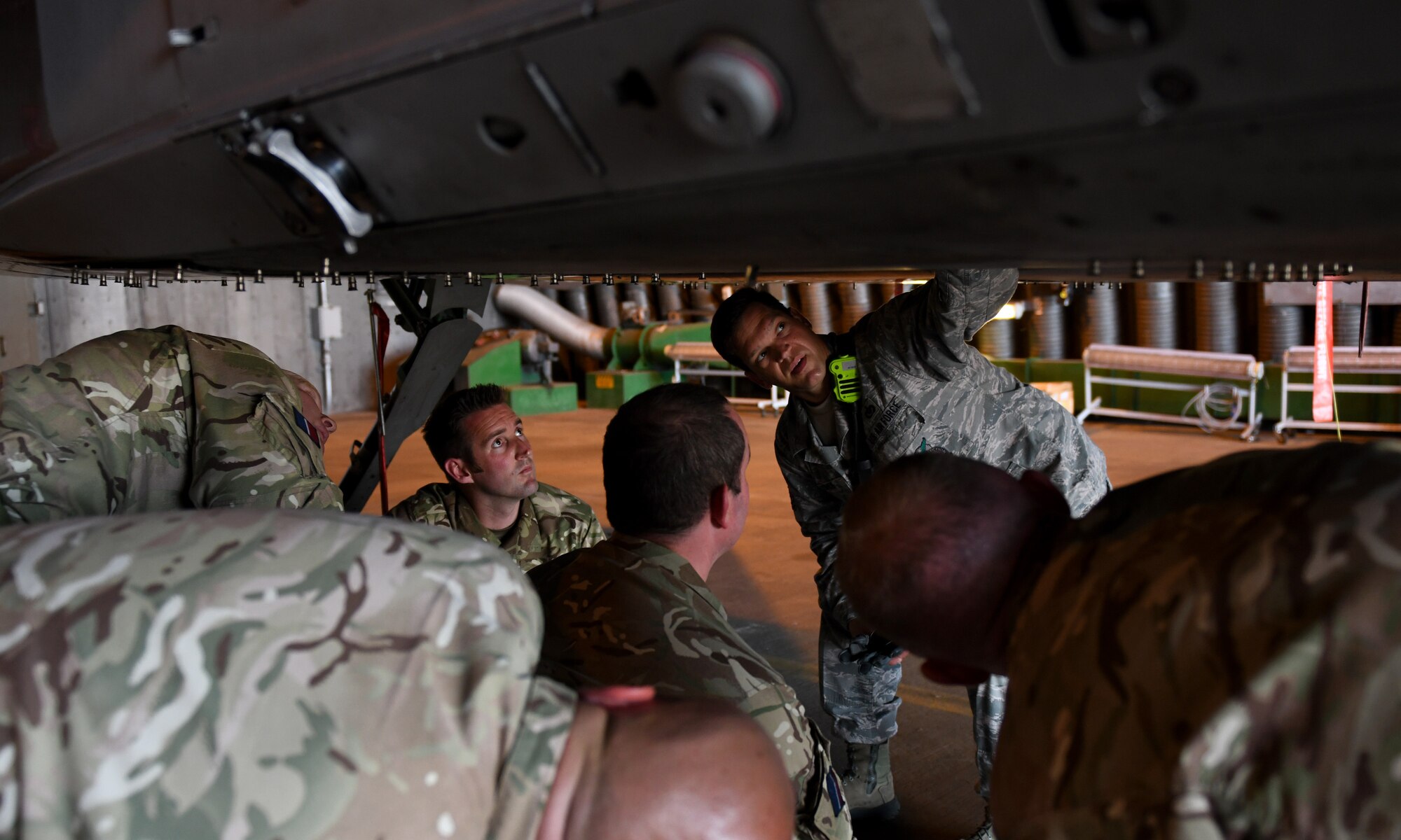 U.S. Air Force Tech. Sgt. Andrew Kehoe, 48th Civil Engineer Squadron Fire Department NCO in-charge of training, shows Royal Air Force Waddington personnel the underside of an F-15E Strike Eagle at Royal Air Force Lakenheath, England, July 25, 2019. Eight Fire Service members from RAF Waddington visited the base to learn firsthand the procedures, protocols, hazards and risks associated with taking care of an emergency involving an F-15 from their U.S. counterparts. (U.S. Air Force photo by Staff Sgt. Alex Fox Echols III)